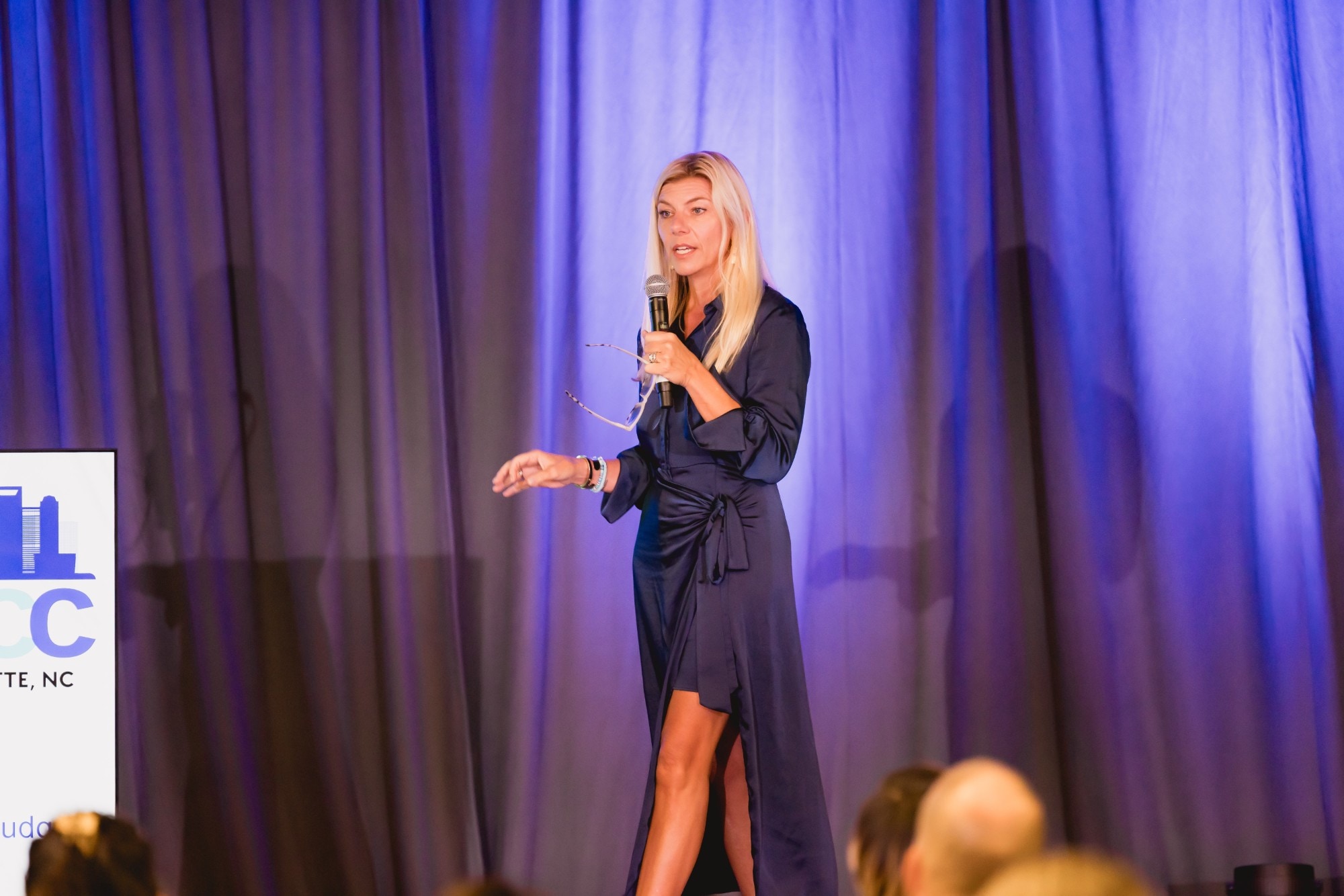 Molly Grantham speaking on stage in a navy dress